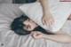 A woman laying on a bed with a pillow on her head.