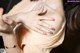 A close up of a woman's breasts with a bracelet on her wrist.