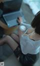 A woman sitting on a couch with a laptop and a cup of coffee.