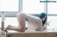 A woman laying on top of a kitchen counter next to a window.