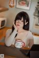 A woman sitting at a table with a laptop and a cup of coffee.