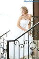 A woman in a wedding dress is sitting on the stairs.