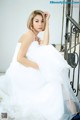 A woman in a white dress sitting on a staircase.