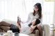 A woman sitting on a couch reading a book next to another woman.