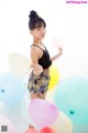 A woman standing in front of a bunch of balloons.