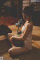 A woman sitting on the floor holding a watermelon.