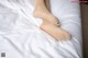 A woman's bare feet on a bed with white sheets.