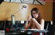 A woman sitting at a desk with a pen in her hand.
