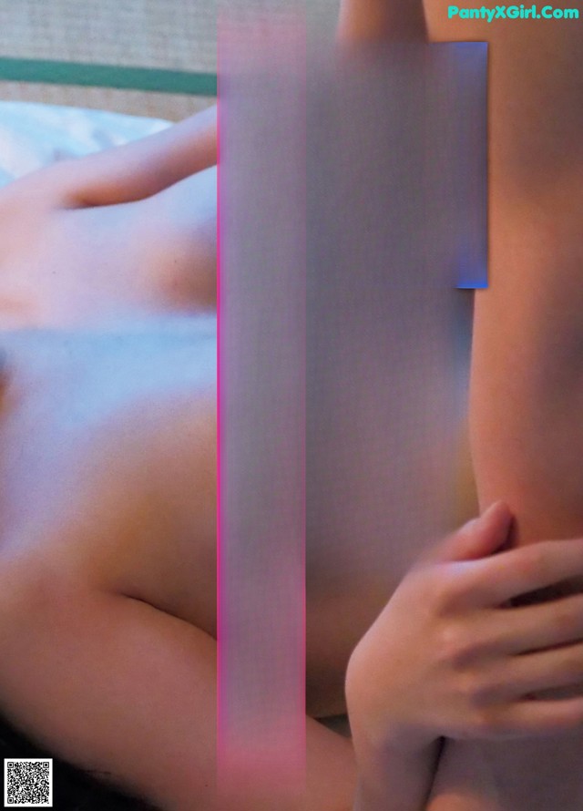 A woman laying on top of a bed next to another woman.