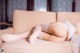 A woman laying on a couch in a white lingerie.