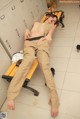 A woman laying on a bench in a locker room.