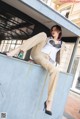 A woman sitting on top of a bus stop.