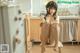 A woman sitting on a stool in a kitchen.