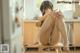 A woman sitting on a stool in a kitchen.