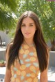 A young woman in a pineapple print dress posing for a picture.