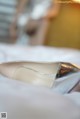 A pair of wedding shoes sitting on top of a bed.