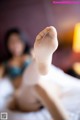 A woman laying on a bed with her feet up in the air.