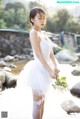 A woman in a white dress holding a bouquet of flowers.