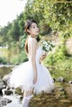 A woman in a white dress holding a bouquet of flowers.