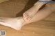 A woman's bare feet on a wooden floor.