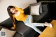 A woman in a yellow top and jeans sitting on a couch.