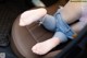 A woman sitting in the back seat of a car with her feet up.