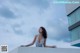 A woman in a white dress standing on a ledge.