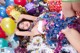 A woman laying on top of a pile of presents and balloons.